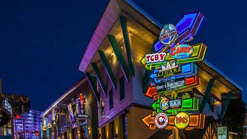 Brightly colored neon signs guide tourists through City Walk at Universal Studios in Orlando,