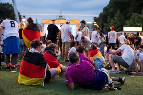 Fassball fans celebrate and gather information in the fan zone at the Brandenburg Tor after the