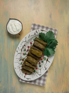 Dolma, cabbage rolls in grape leaves, Traditional Armenian dish, with white sauce, top view,