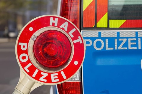 Police control: Close-up of a police trowel with the inscription HALT POLIZEI in front of a police