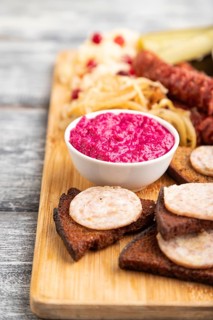Set of snacks: sausages, toast, sauerkraut, marinated onion and cucumber, baked potato on a cutting