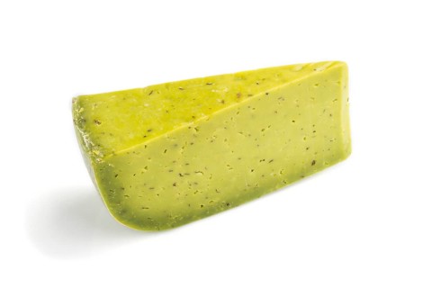 Piece of green cheese with basil isolated on white background. Side view, close up