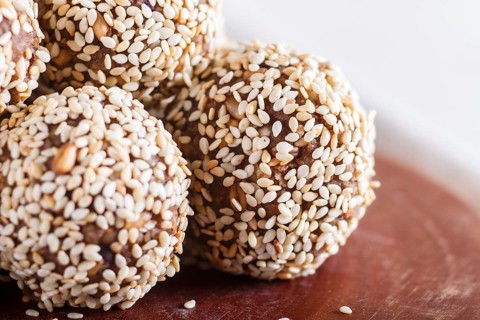 Energy balls cakes with almonds, sesame, cashew, walnuts, dates and germinated wheat on wooden