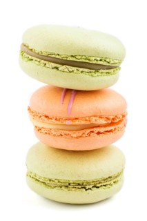 Orange and green macarons or macaroons cakes isolated on white background. side view, close up,