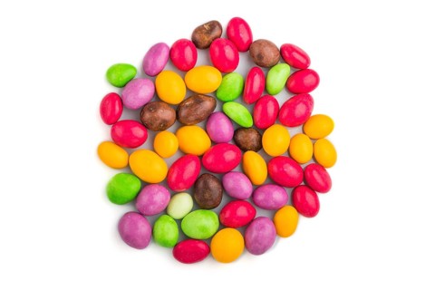 Pile of multicolored candies isolated on white background, chocolate dragees. close up, top view,