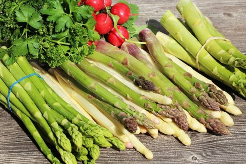 Green asparagus and white asparagus decorated on a rustic wooden table