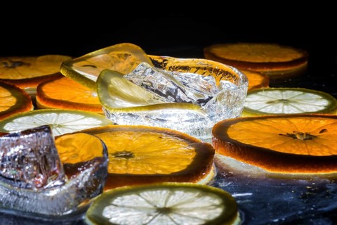 Transparent slices of fresh oranges and lemons on the glass with ice