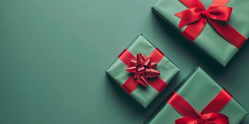 Top view of Christmas gift boxes with red ribbon on green background with copy space. Generative