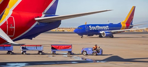 Oakland, California, A worker pulls bagge carts around Southwest Airlines planes at Oakland