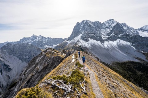 Two mountaineers on a hiking trail on the ridge of Hahnkampl, mountain panorama with rocky steep