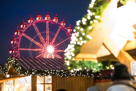 Ferris wheel behind a stand at the Christmas market on Alexanderplatz, Berlin, 21.12.2024