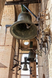 Close-up of an ancient bell tower with massive bells and metal structures, Seville