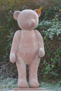 Red Steiff bear figurine, stone sculpture with trademark button in ear, emblem, brand name,