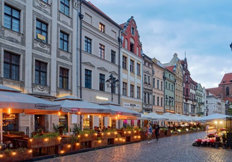 The lights come on in the evening in the restaurants on Chelminska Street in the historic centre of
