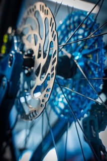 Close-up of a blue brake disc with spokes of a bicycle, Waldbike Manufaktur, bicycle workshop,
