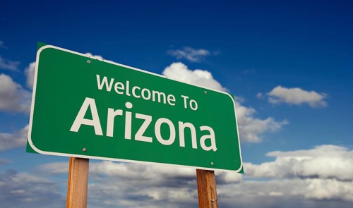 Welcome to arizona green road sign over blue sky with some clouds
