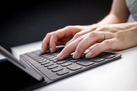 Hands typing on a tablet with keyboard in Berlin, 09/08/2024