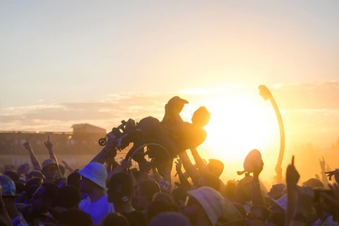 A wheelchair user crowdsurfing in front of sunset at the Highfield Festival on Friday, Störmthaler