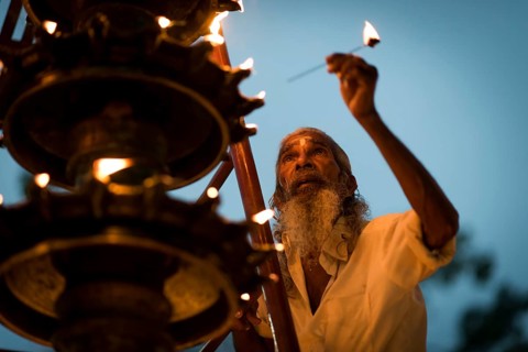 Old man lights oil lamp for Hindu fire ceremony Aarti, Ambalapuzha, Kerala