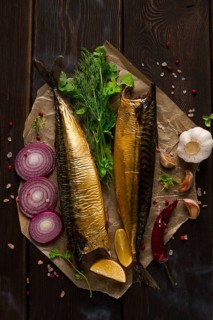 Smoked mackerel, top view, with spices, on a wooden table, no people, selective focus