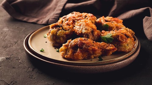 Fried chicken legs, breaded, with spices and herbs, on a dark background, horizontal, no people,