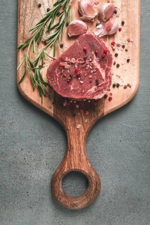 Fresh, raw rib eye steak, on a chopping board, top view, no people