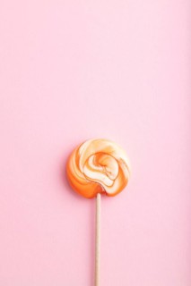Single lollipop candy on pink pastel background. copy space, top view, flat lay