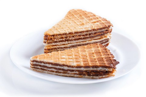 Waffle sandwiches with boiled condensed milk in plate isolated on white background. closeup