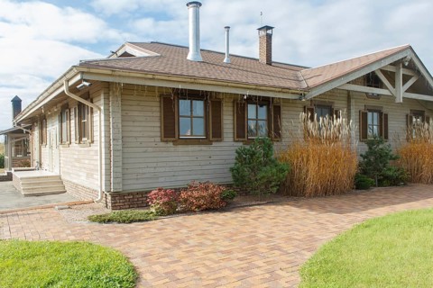 Modern restaurant with green lawn, tile path and landscape design with ornamental grasses and
