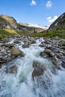 Mountain stream Hornkeesbach, behind mountain peak with snow and glacier Hornkees, Berliner