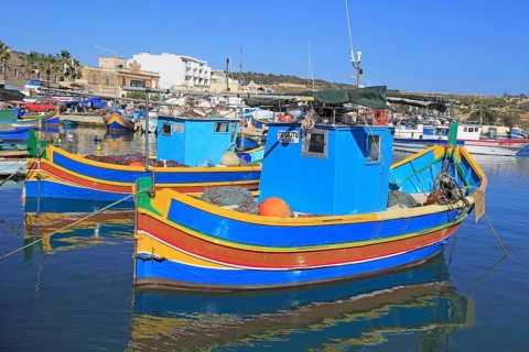 Colourful traditional fishing boats called luzzu in the harbour at Marsaxlokk, Malta, Europe