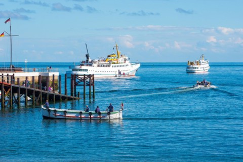 Two white ferries, 'Fair Lady' and 'Lady von Büsum', embarking, embarking off the island of