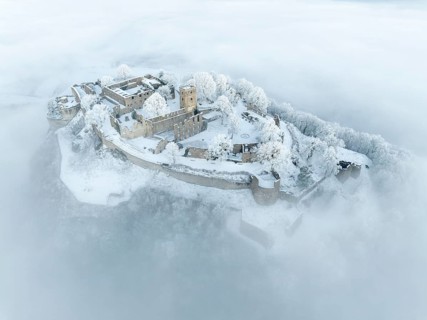 Aerial view of the Hegau volcano Hohentwiel with Germany's largest fortress ruins on a cold, foggy
