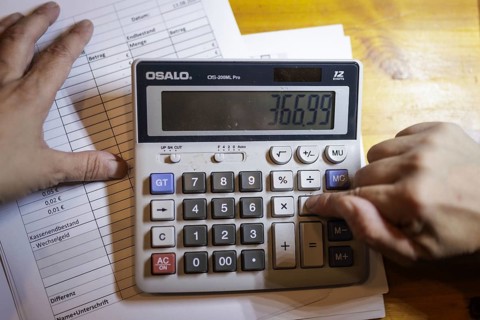Symbolic photo on the subject of accounting: A calculator stands next to documents on an office