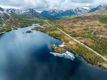 Gaularfjell mountain crossing, typical red norwegian house on an island, aerial view, national
