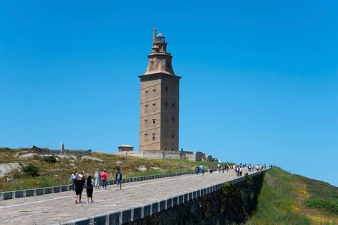Lighthouse with many visitors on the way there, in sunny weather and blue sky, Torre de Hércules,