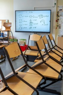 Classroom of a fourth grade, after school, the building is older but in good condition, modern