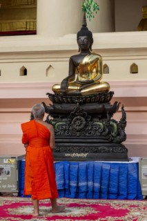 Monk in front of a Buddha statue, Bhumispara-mudra, Buddha Gautama at the moment of enlightenment,
