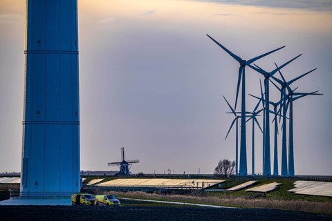 Windmill Poldermolen De Goliath stands between the high-tech wind turbines in Eemshaven, historic