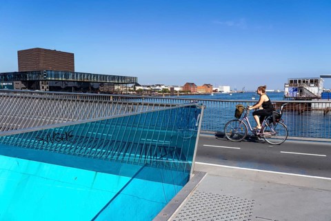 Cyclists on the Inderhavnsbroen cycle and footpath bridge, over the harbour, at Nyhavn, Copenhagen
