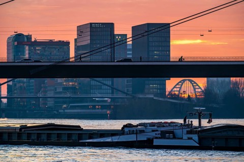Winter sunset on the Rhine near Düsseldorf, houses in the media harbour, cargo ship,