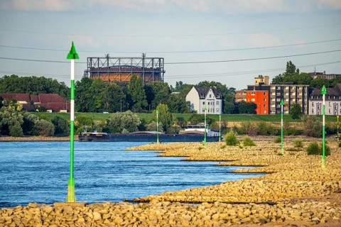 Cargo ship at low water on the Rhine near Duisburg-Homberg, view of Duisburg-Laar, houses on