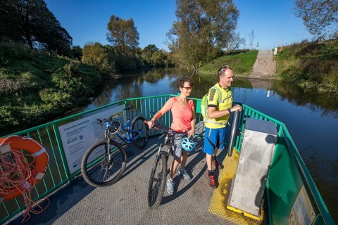 Cyclist, cycle tour, manually operated ferry across the Lippe near Halten am See, on the