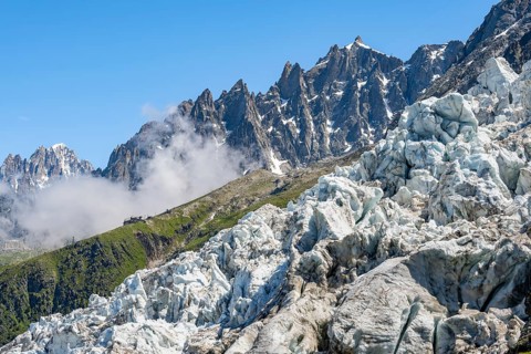 Glacier ice of the Glacier des Bossons, pointed mountain peaks in the background, Chamonix,