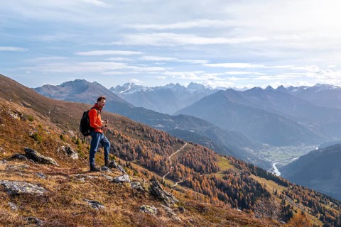 Mountaineer in front of mountain panorama, view from Venet into the Upper Inn Valley, in autumn,