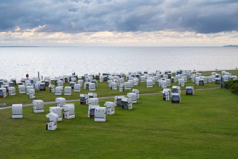 Beach chairs on the green beach, Dramatic sky over the North Sea, View from above, Norddeich, East