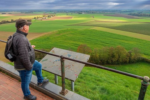 Elderly man looking over the 1815 Waterloo battlefield from top of the Lion's Mound at sunset in