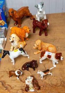 Variety of China dog models of different breeds on display as a lot in auction room, UK