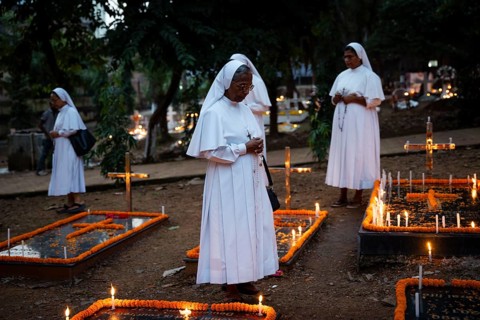 Nuns offer prayers on the grave during the All souls day observation, in Guwahati, India on 2