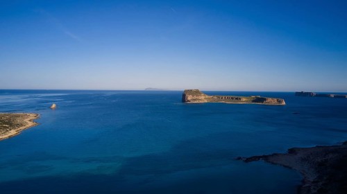 Drone shot, Remote island with wide view of the clear blue ocean and bright sky, Venetian Sea